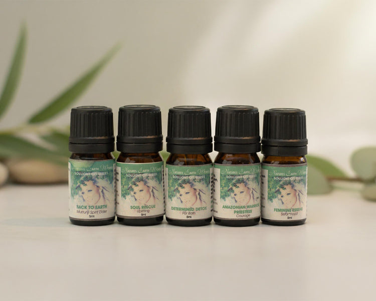 Five small bottles of Aromatic Wellness Oils from Natures Earth Works, in a row.