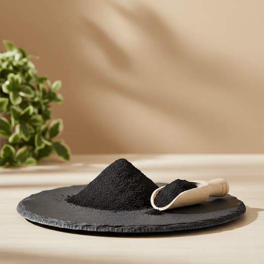 Bohemian Black Clay powder with a scoop on a slate, a purifying skincare ingredient.