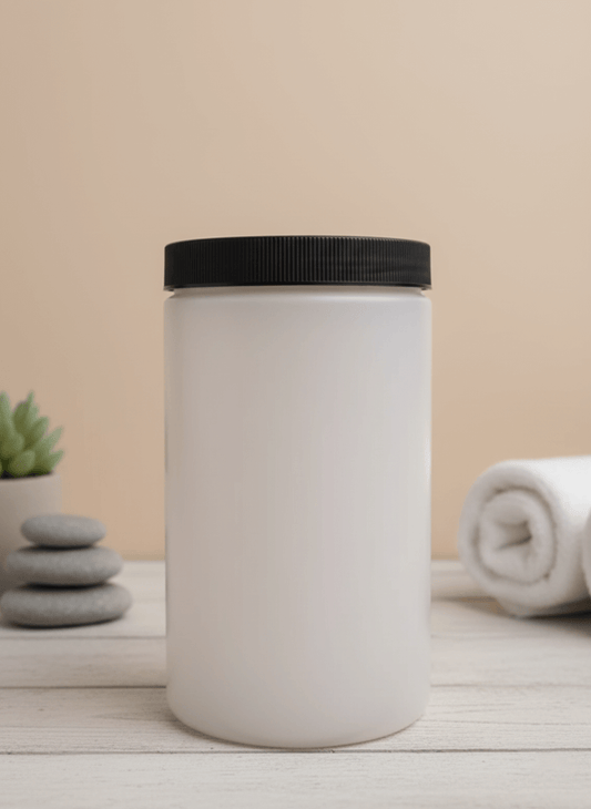 A matte white plastic bottle with a black lid, next to stacked stones and a towel.