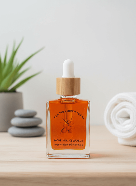 A bottle of Moor Mud Organics Sea Buckthorn Serum in a spa setting with stones and a plant.